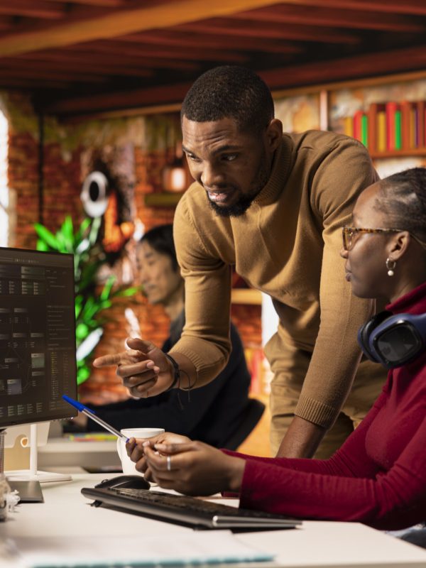 Teamworking startups employees leveraging machine learning technology in office to gain competitive edge. Silicon Valley company colleagues collaborating to do rapid technological advancement